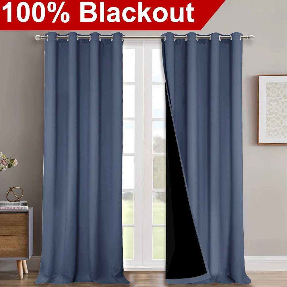 Two panels of blue double layer blackout living room curtains with silver grommets, revealing the noise reducing black lining.