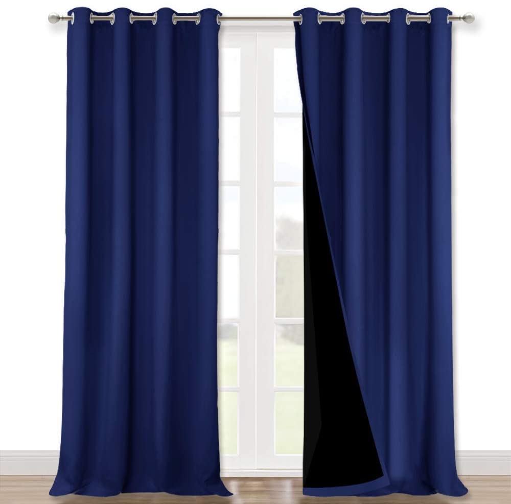 Pair of navy blue double layer noise reducing living room curtains with silver grommets, revealing thick black lining.