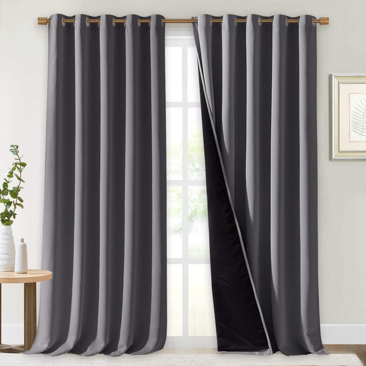 Dark gray double layer noise reducing curtains with silver grommets for living room, one panel revealing black inner lining.