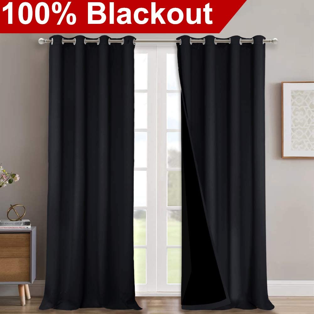 Black double-layer noise reducing blackout curtains with silver grommets, one panel slightly open, '100% Blackout' banner.