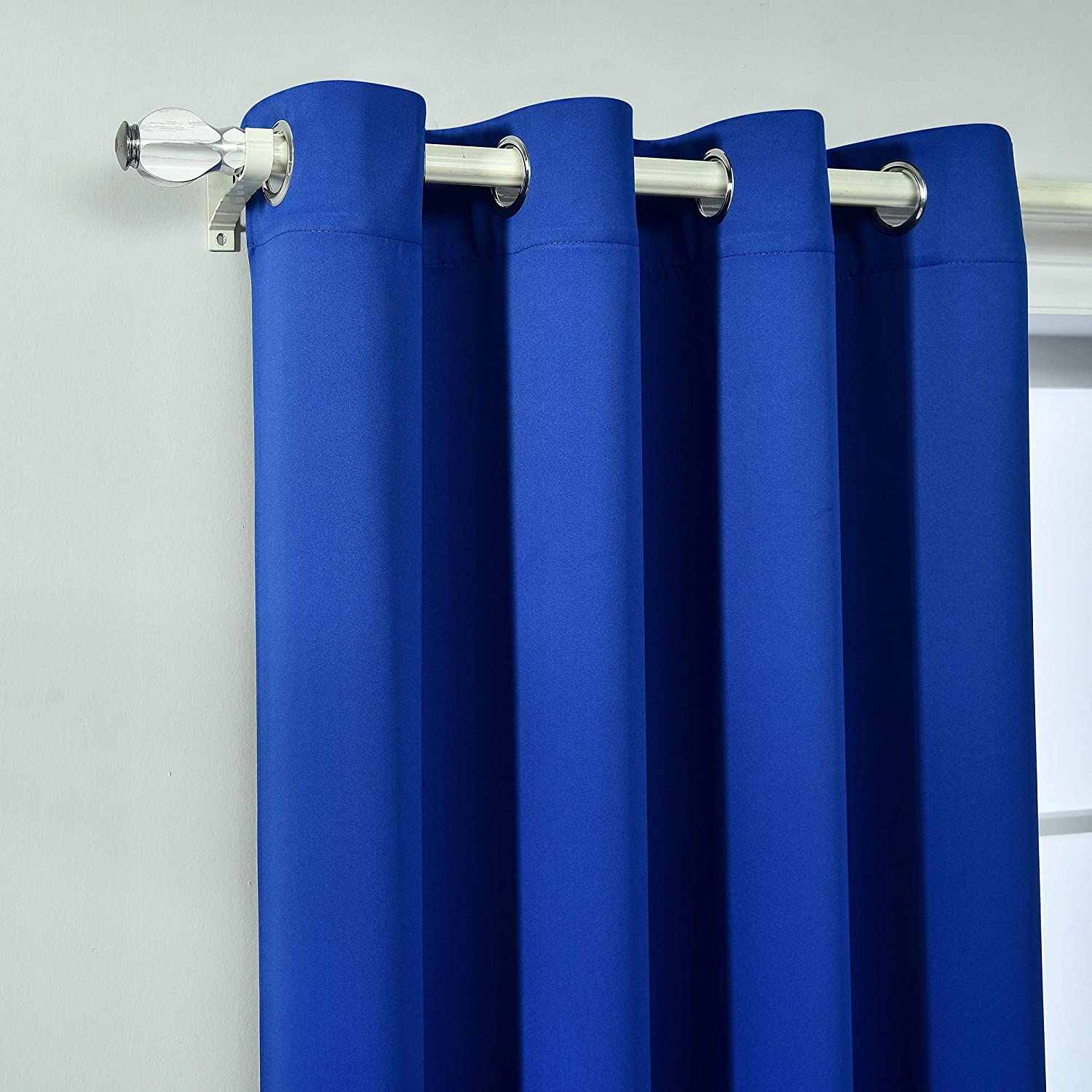 Close-up of royal blue grommet blackout thermal insulated curtain panel on a silver rod, ideal for living room or bedroom.
