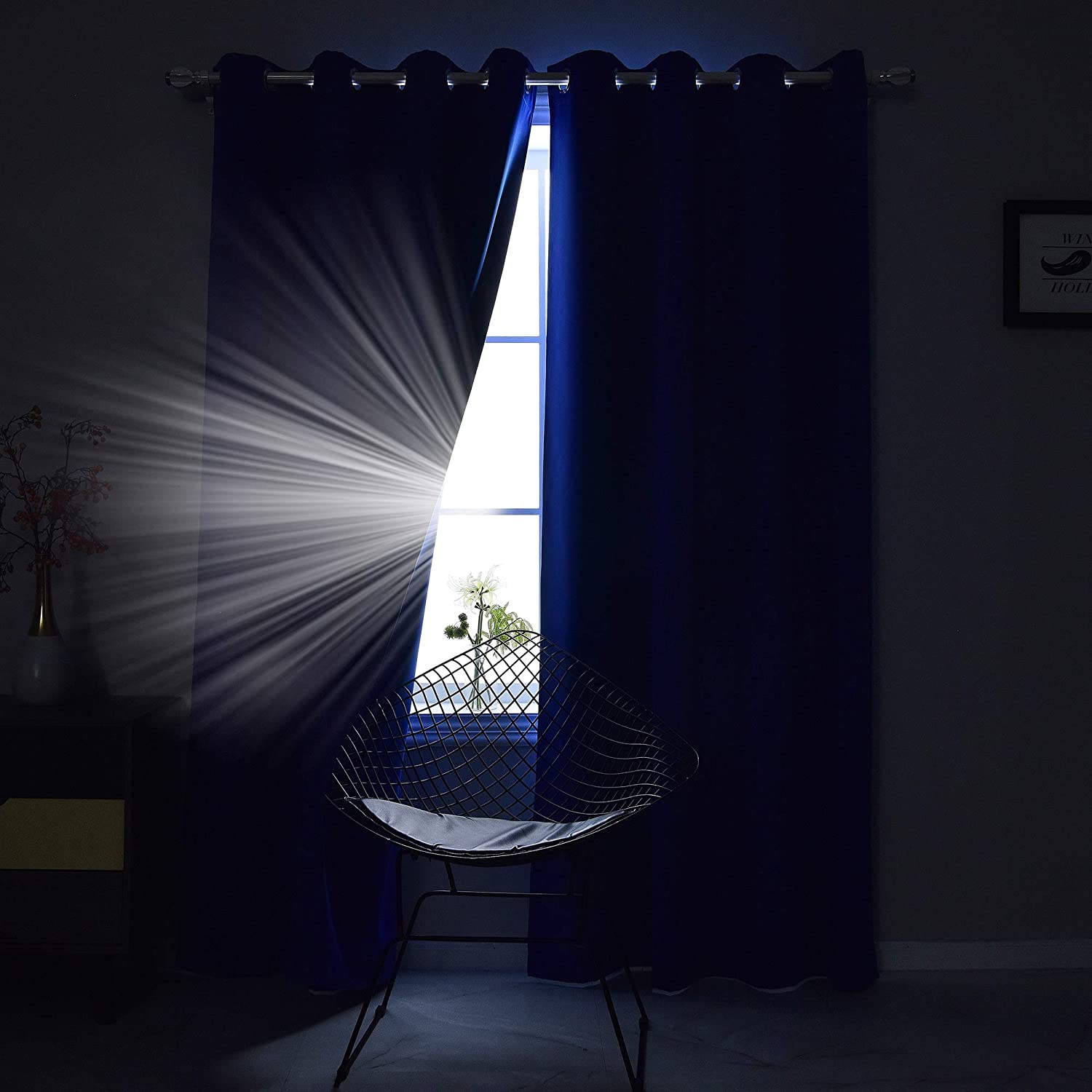 Dark blue grommet blackout thermal insulated curtains effectively blocking light in a living room or bedroom.