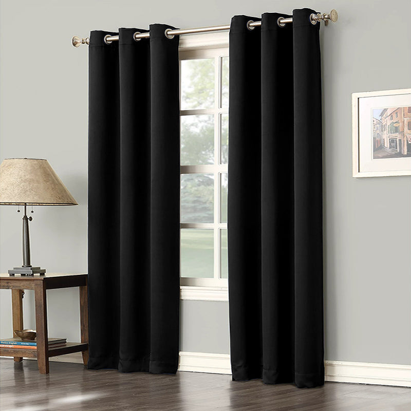 Two black grommet blackout curtains (2 panels) installed in a bedroom or living room window, offering noise reduction and privacy.