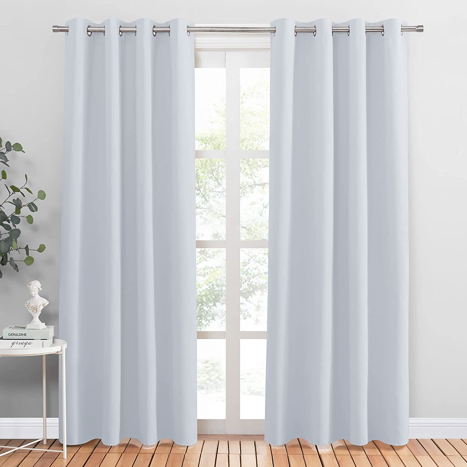 Two light gray grommet blackout curtains for living room and bedroom, offering noise reduction and privacy over a window.