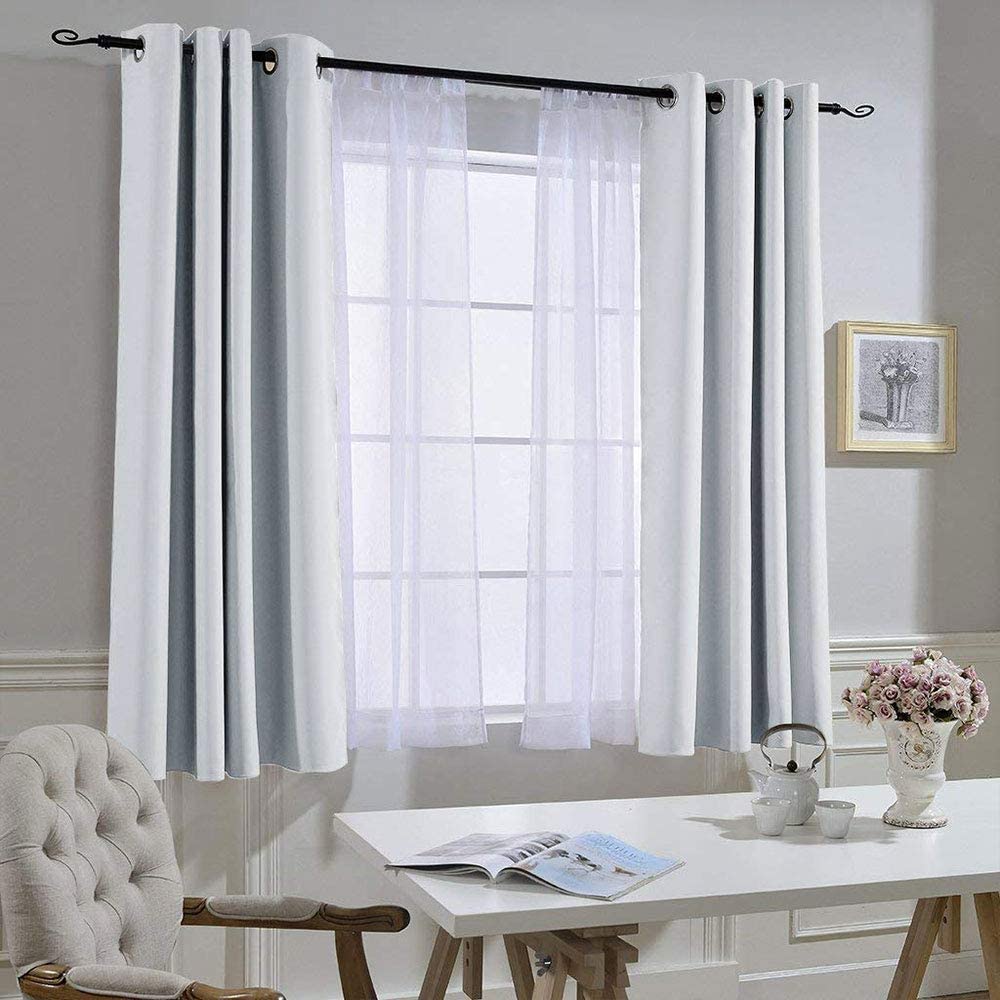 Two light gray noise reducing blackout curtains with grommets & sheer panels, installed on a living room/bedroom window.