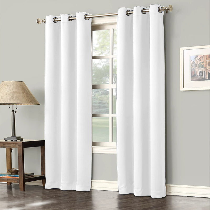 Two white grommet noise reducing blackout curtain panels covering a window in a living room or bedroom.