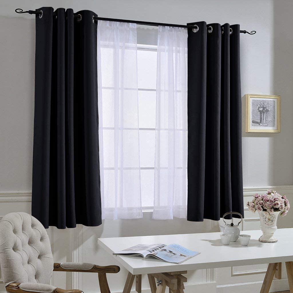 Two black grommet noise-reducing blackout curtain panels and sheer white curtains on a living room window.