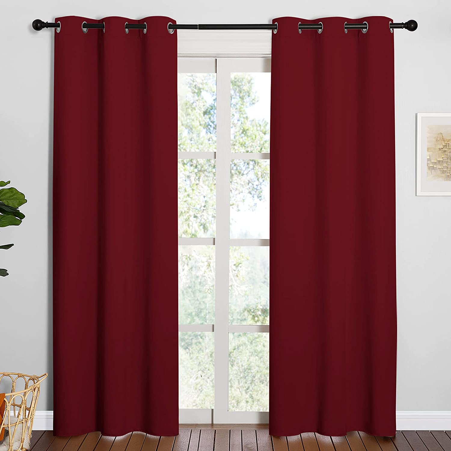 Two deep red grommet thermal insulated blackout curtain panels covering a living room window.