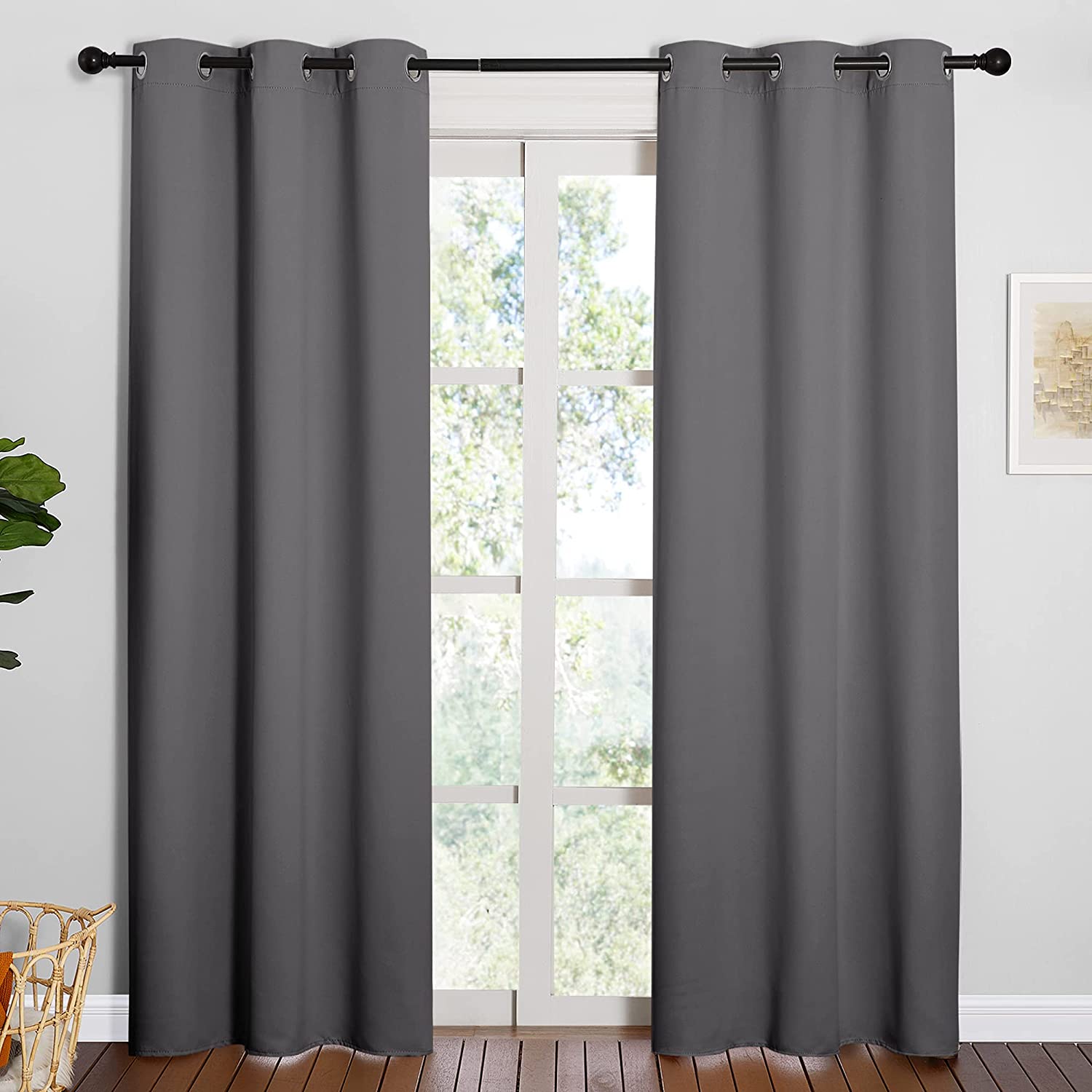 Two charcoal gray grommet thermal insulated blackout curtain panels on a living room window, providing privacy.