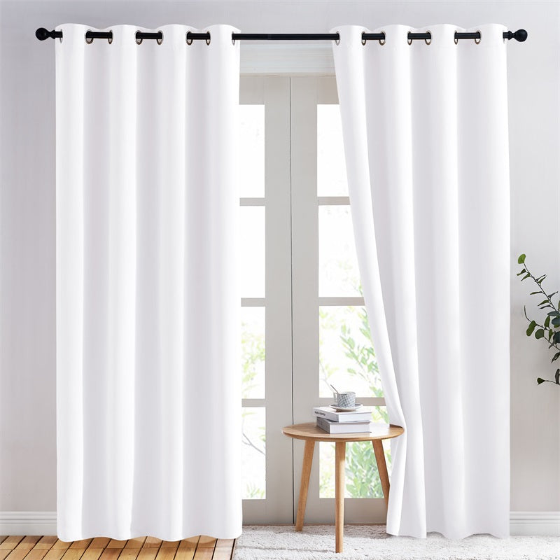 White thermal insulated grommet blackout curtains (2 panels) on a rod, partially open over a living room glass door.