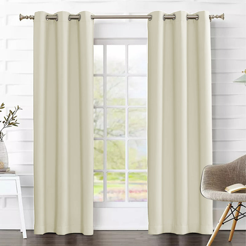 Two cream grommet thermal insulated blackout curtains on a living room window, providing privacy & energy efficiency.