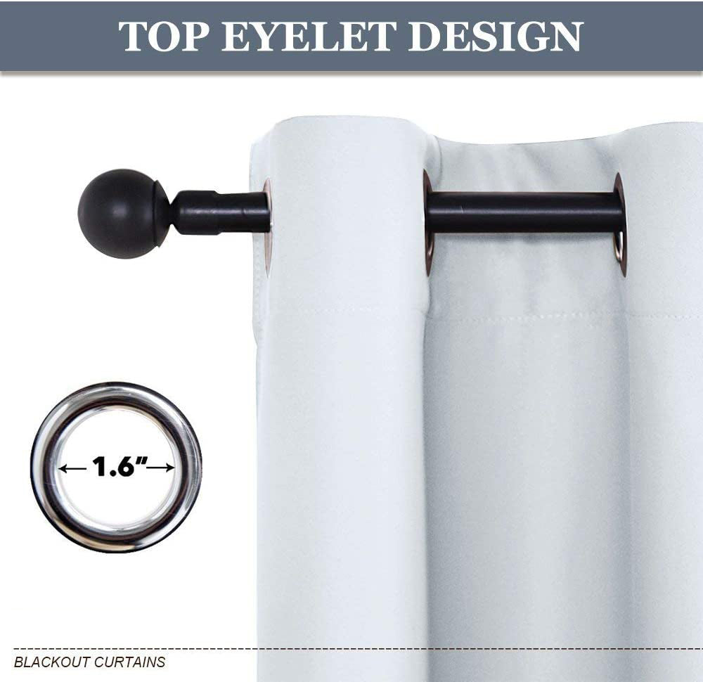 Detail of 1.6" grommet top eyelet design on white thermal insulated blackout weave curtains, mounted on a black curtain rod.