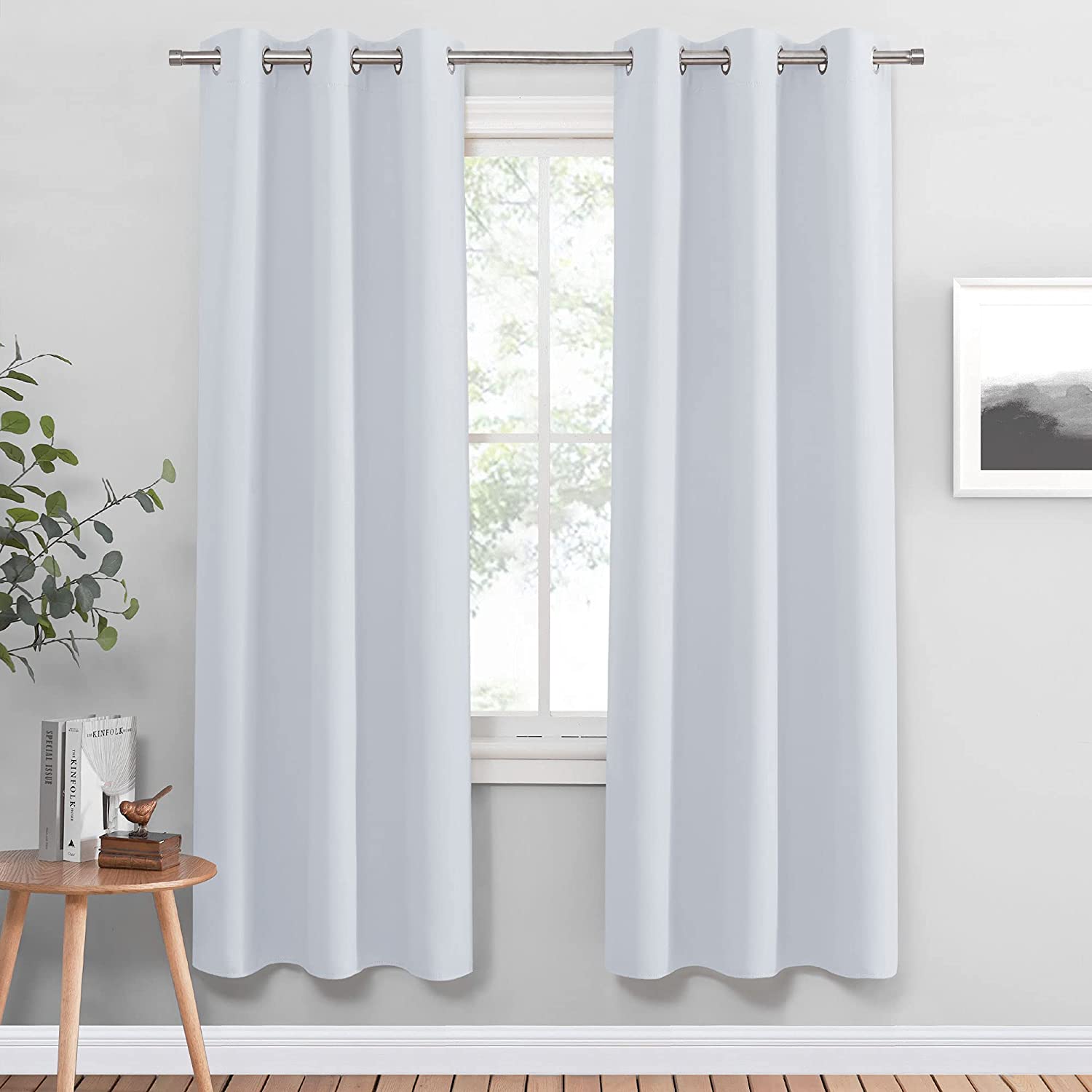 Two light grey thermal insulated blackout grommet curtains in a living room, providing privacy and light control.
