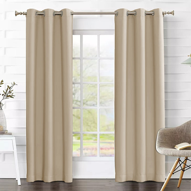 Two tan grommet thermal insulated blackout weave curtain panels partially drawn across a living room window.