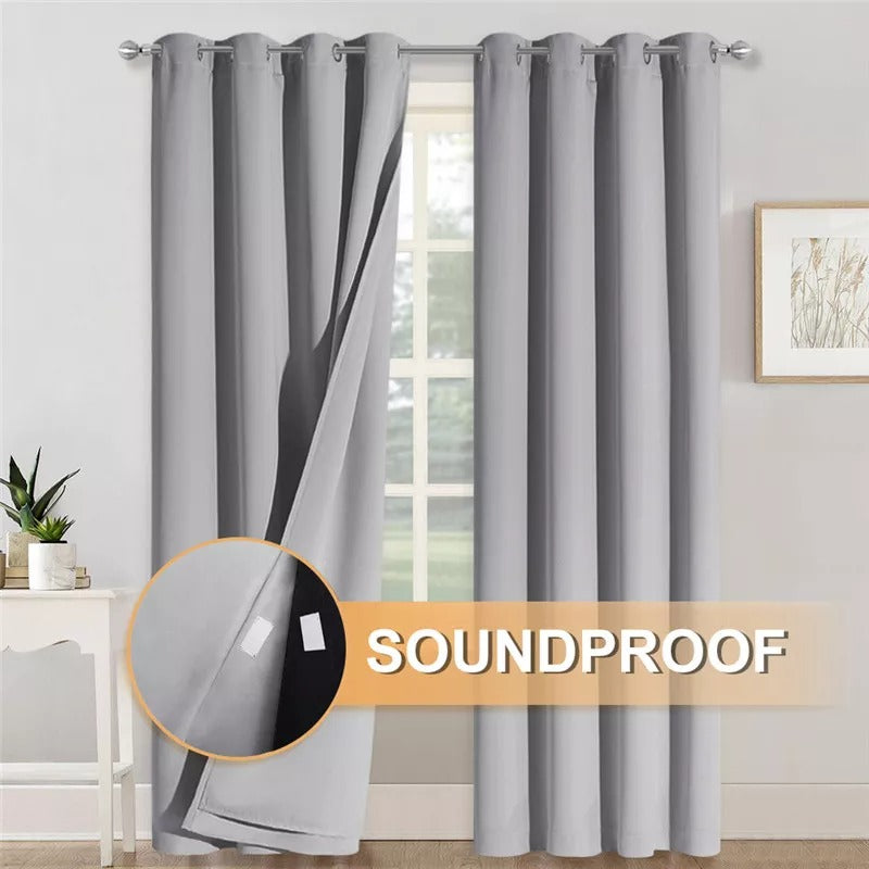 Two grey 3-layer soundproof blackout grommet curtains, with one pulled back revealing the thick thermal fabric.
