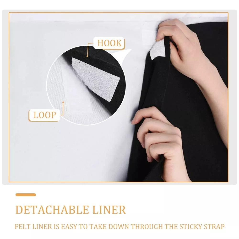 Hands detaching a black thermal soundproof blackout curtain's felt liner using hook and loop fasteners for easy cleaning.