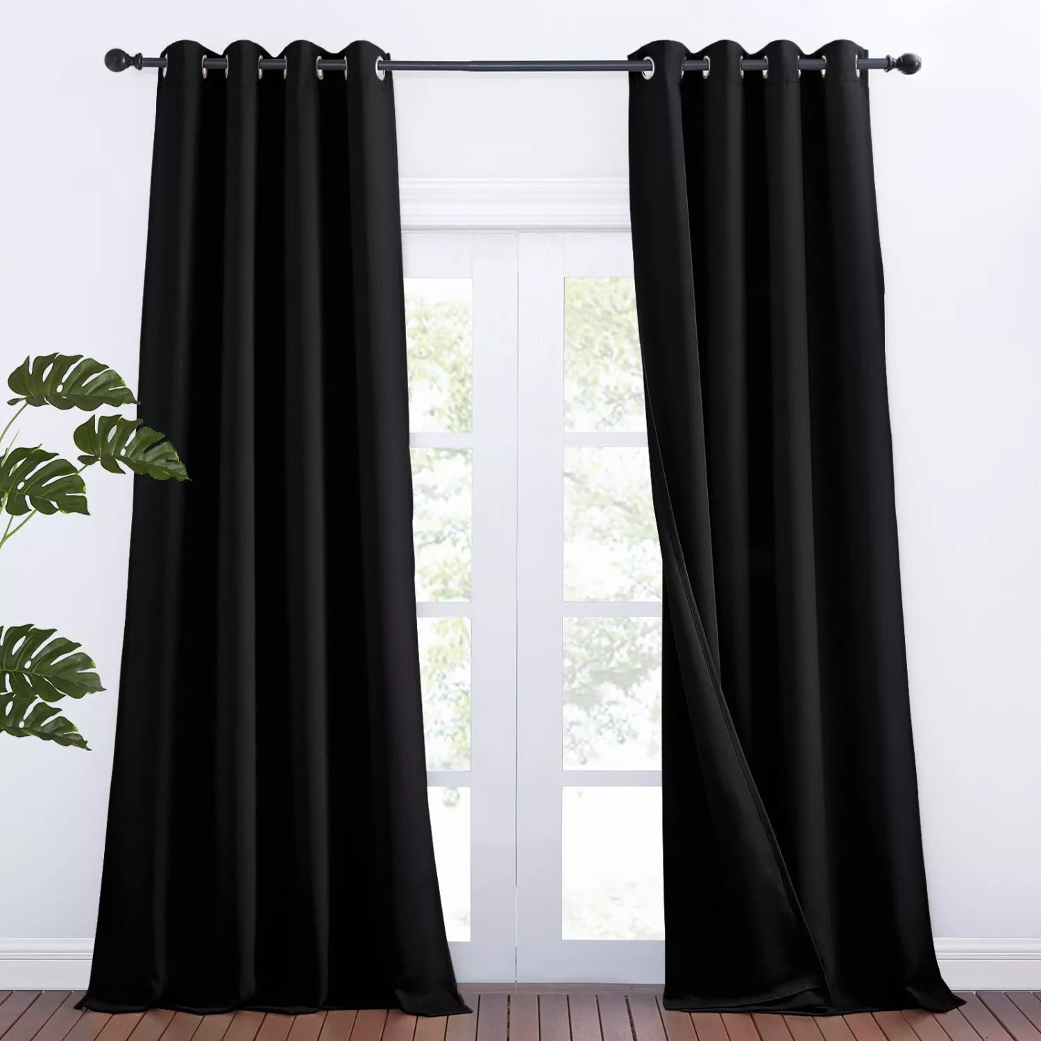 Two black grommet 3-layer thermal soundproof blackout curtain panels, perfect for a living room or bedroom.