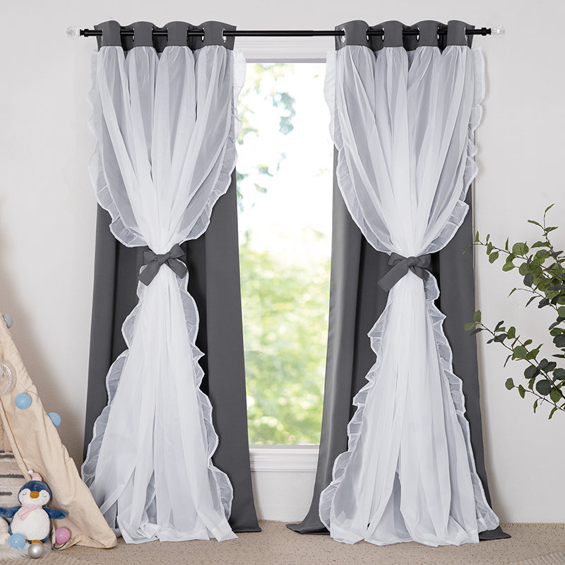 Two grey grommet top blackout curtains with white ruffled sheer overlay, tied back, for elegant room darkening and privacy.