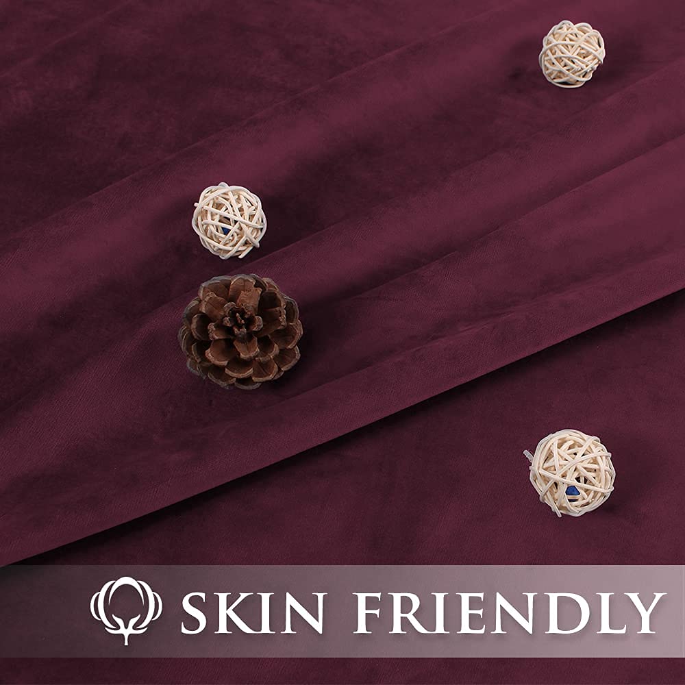 Close-up of deep red velvet blackout curtain fabric with soft, plush texture. Features 'SKIN FRIENDLY' icon and text.