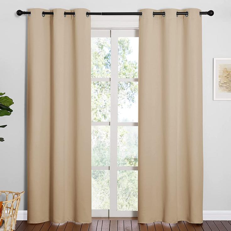 Pair of KGORGE beige blackout curtains with grommets on a rod, offering light-blocking and privacy for any room.