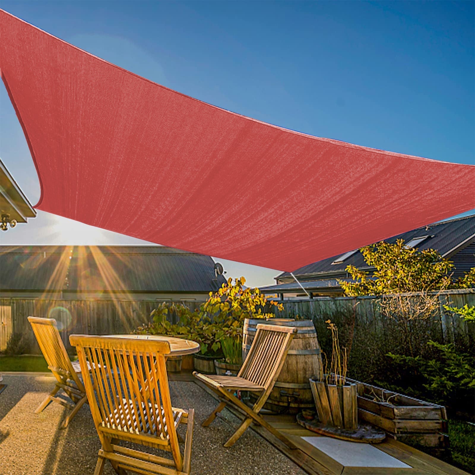 Large red heavy-duty sun shade sail provides waterproof protection over a sunny patio with wooden furniture, perfect for garden awnings.