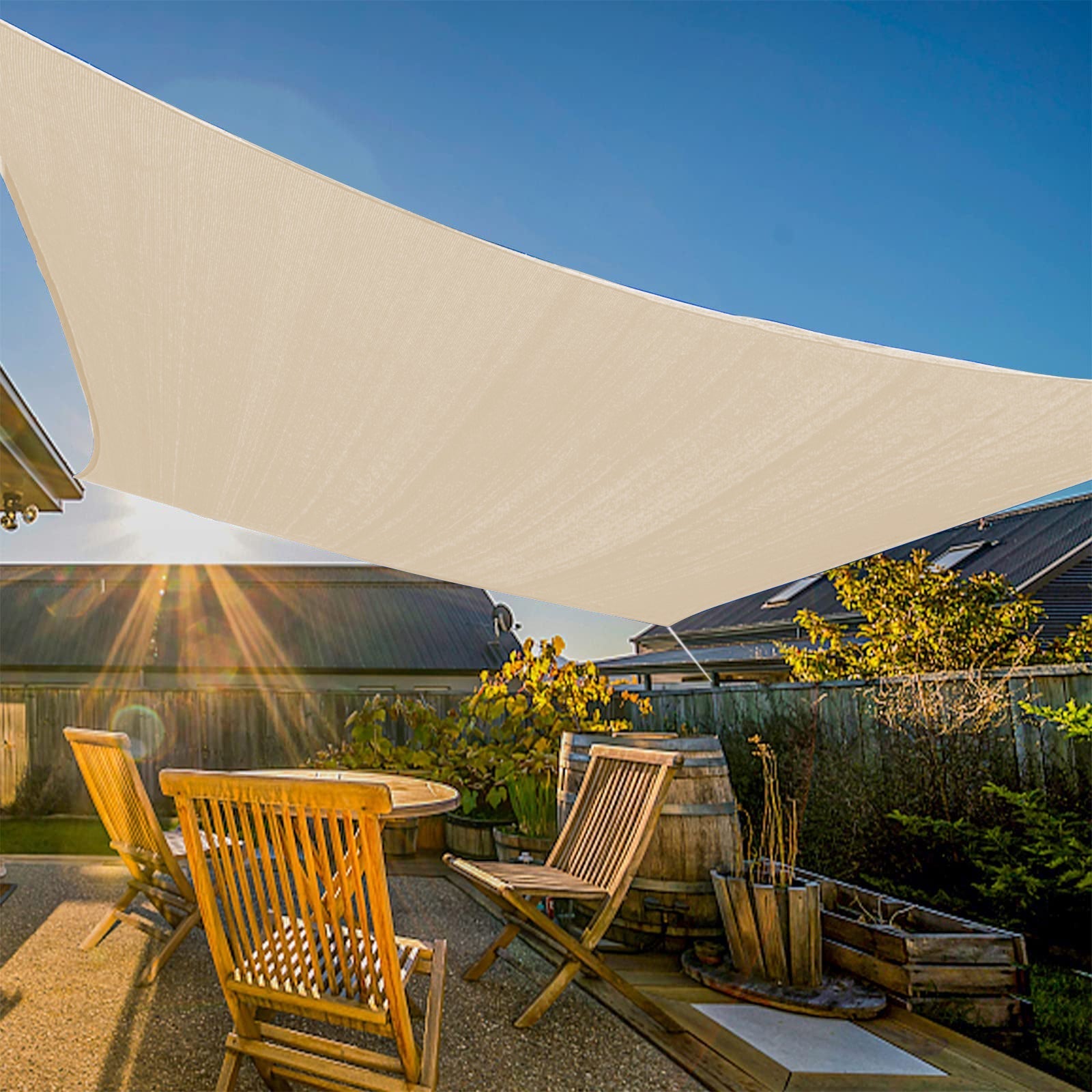 Large beige sun shade sail provides heavy-duty, waterproof shade over a sunny patio with wooden table and chairs, creating a private oasis.