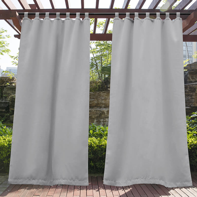 Light grey waterproof tab top outdoor curtains hanging from a wooden pergola, offering shade and privacy for a porch deck.