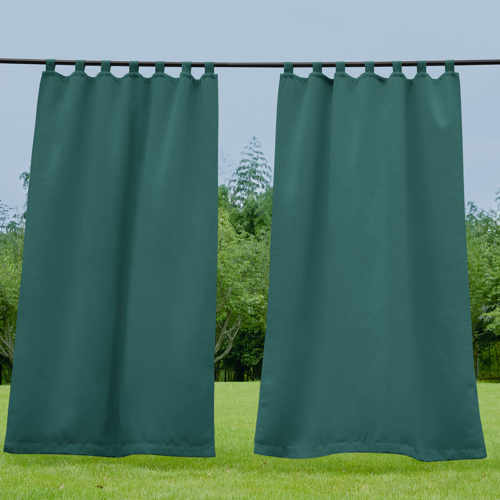 Two dark green waterproof tab top outdoor curtains on a rod, perfect for privacy and shade on a porch, deck, or patio.