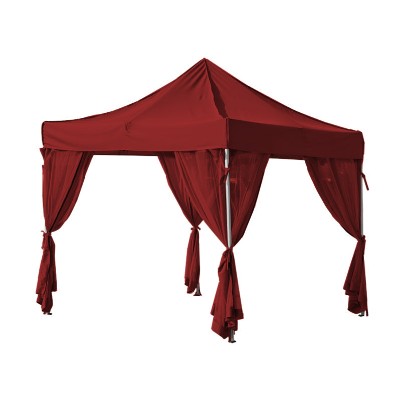 Red outdoor gazebo canopy with sheer zipped mosquito netting sidewall curtain panels, tied back for patio privacy.