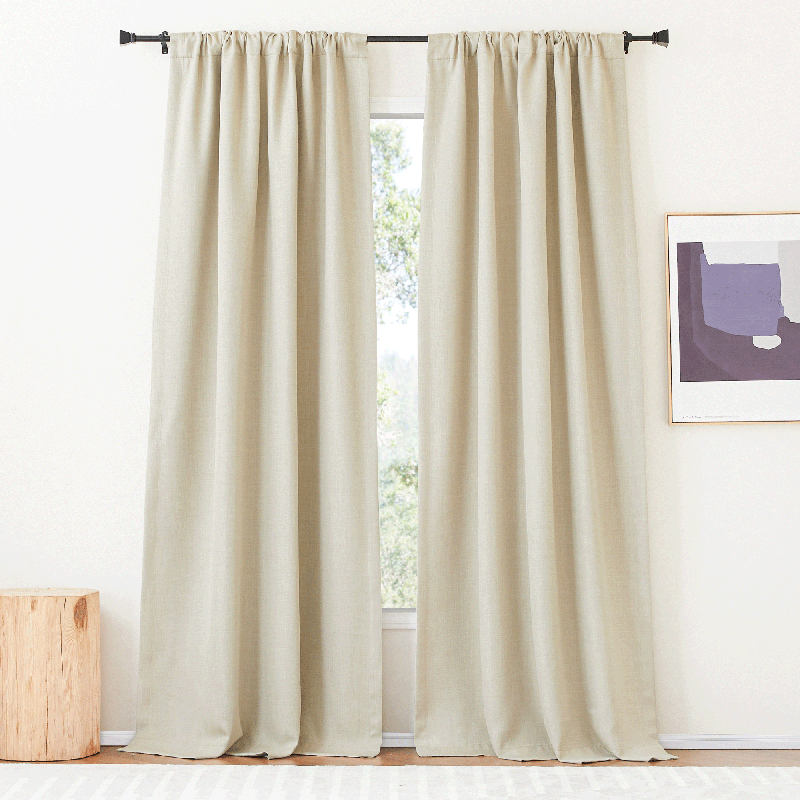 Two plain light beige rod pocket & back tab blackout curtains panels, ideal for living room or bedroom.