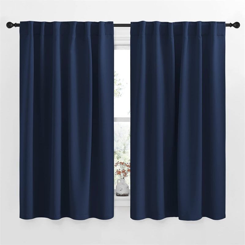 Two navy blue blackout curtains, rod pocket & back tab style, for living room or bedroom, hanging on a window.