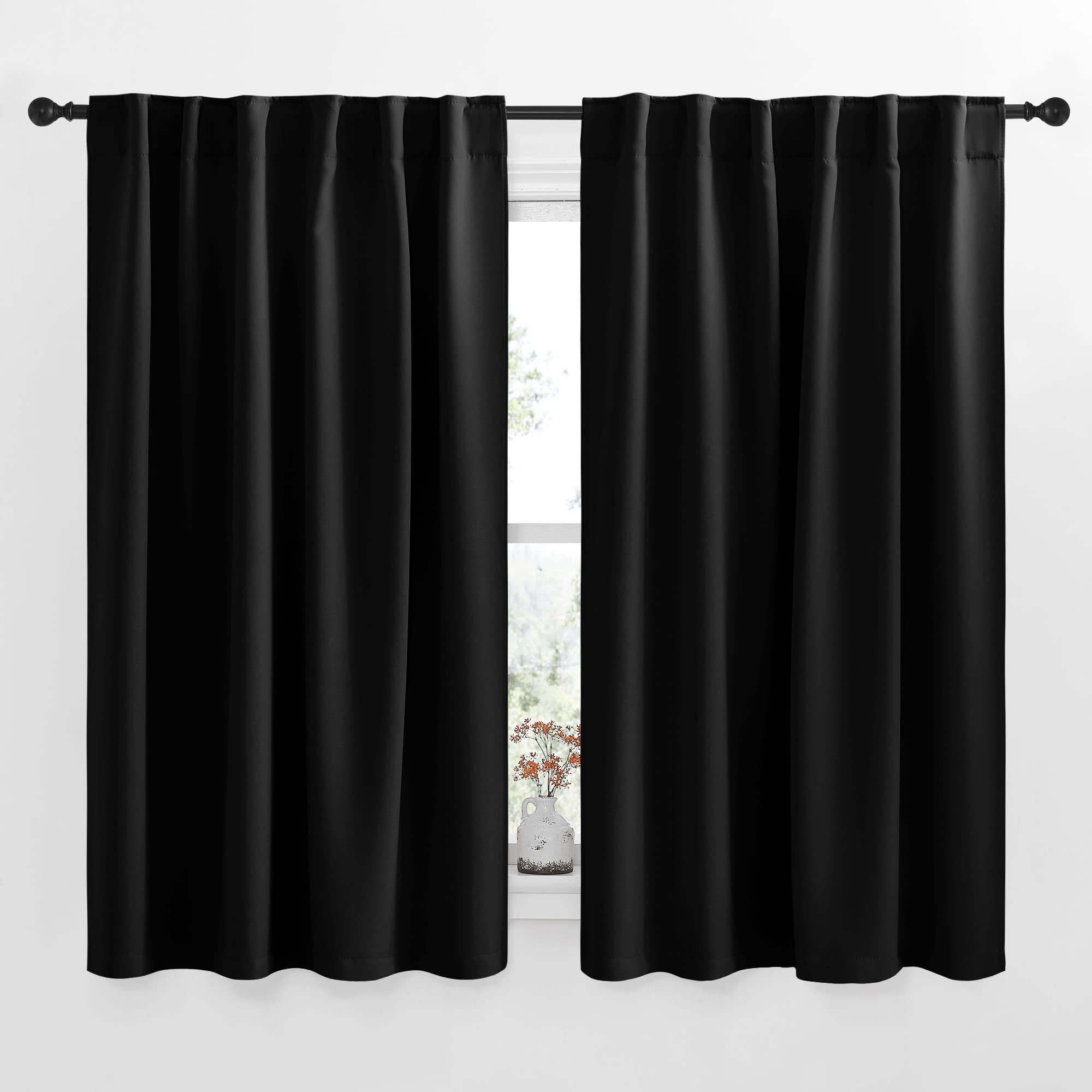 Two 52-inch wide black rod pocket blackout curtain panels for living room & bedroom, partly open, showing a window and vase.