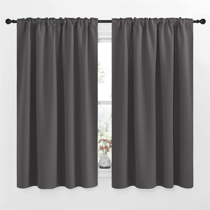 Charcoal gray rod pocket blackout curtain panels (2) on a window, enhancing living room or bedroom privacy.