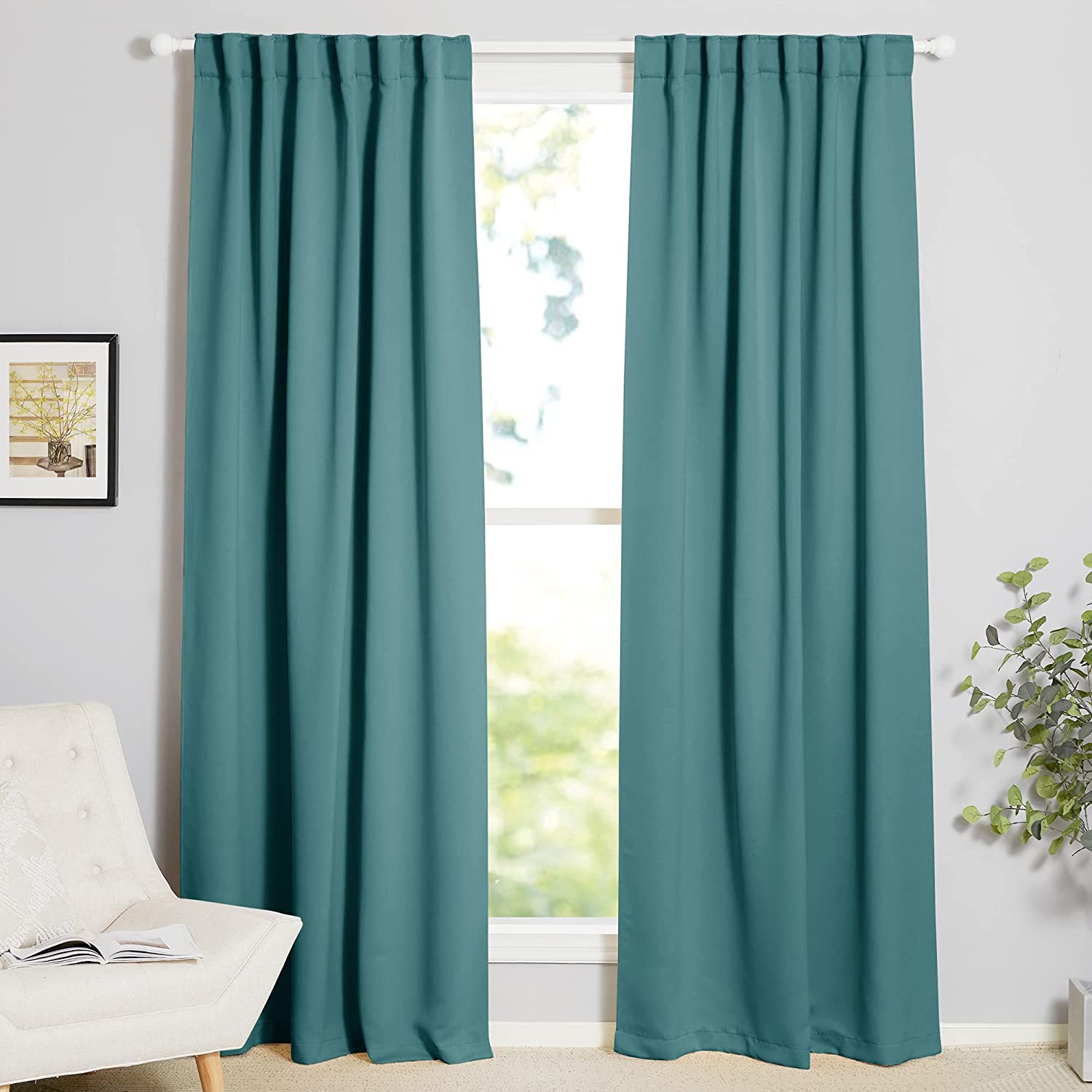 Two teal 70-inch wide thermal insulated blackout curtains with rod pocket & back tab style in a modern living room or bedroom.