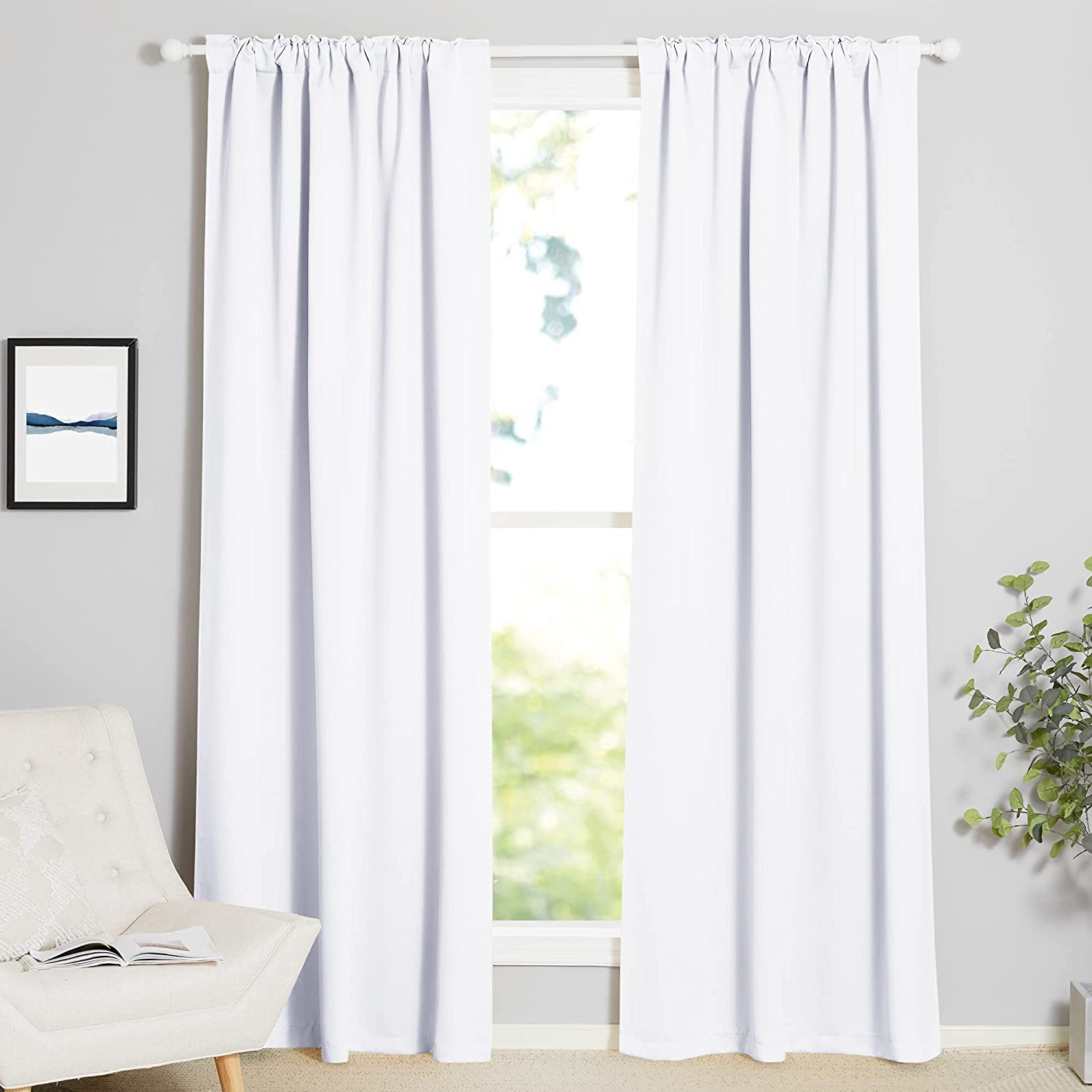 Pair of white thermal insulated blackout curtains with rod pocket and back tab headings, enhancing a bright living room.
