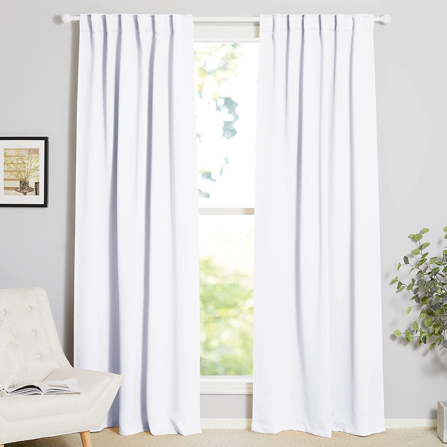 Two white thermal insulated blackout curtains on a rod pocket. Ideal for living room or bedroom light blocking and privacy.
