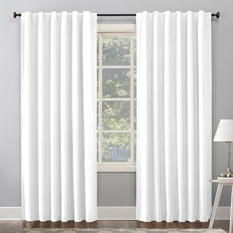 White thermal insulated blackout curtains, rod pocket & back tab style, partially drawn across a living room window for light control.