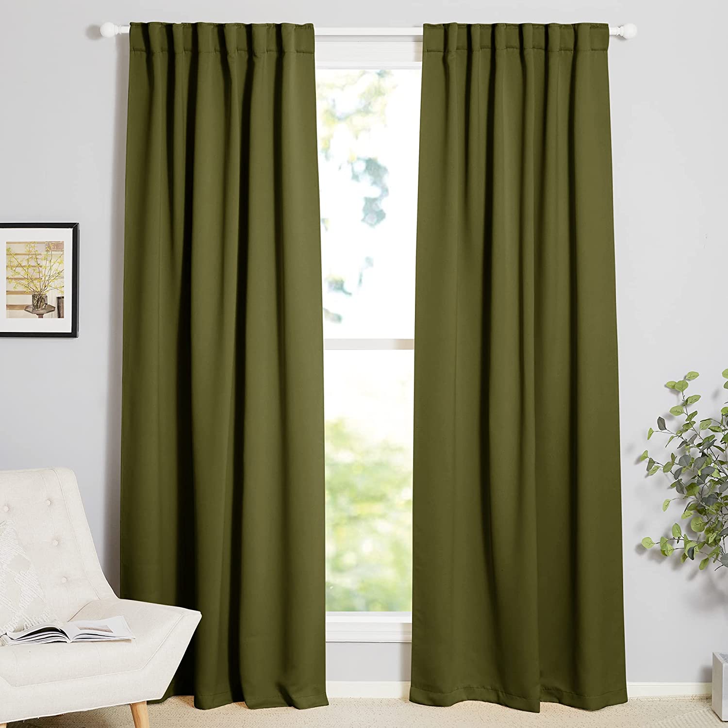 Pair of olive green thermal insulated blackout curtains on a rod, fully covering a window in a living room.