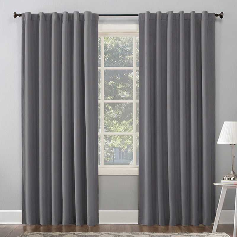 Two gray thermal insulated blackout curtains with rod pocket and back tab hanging on a living room window.