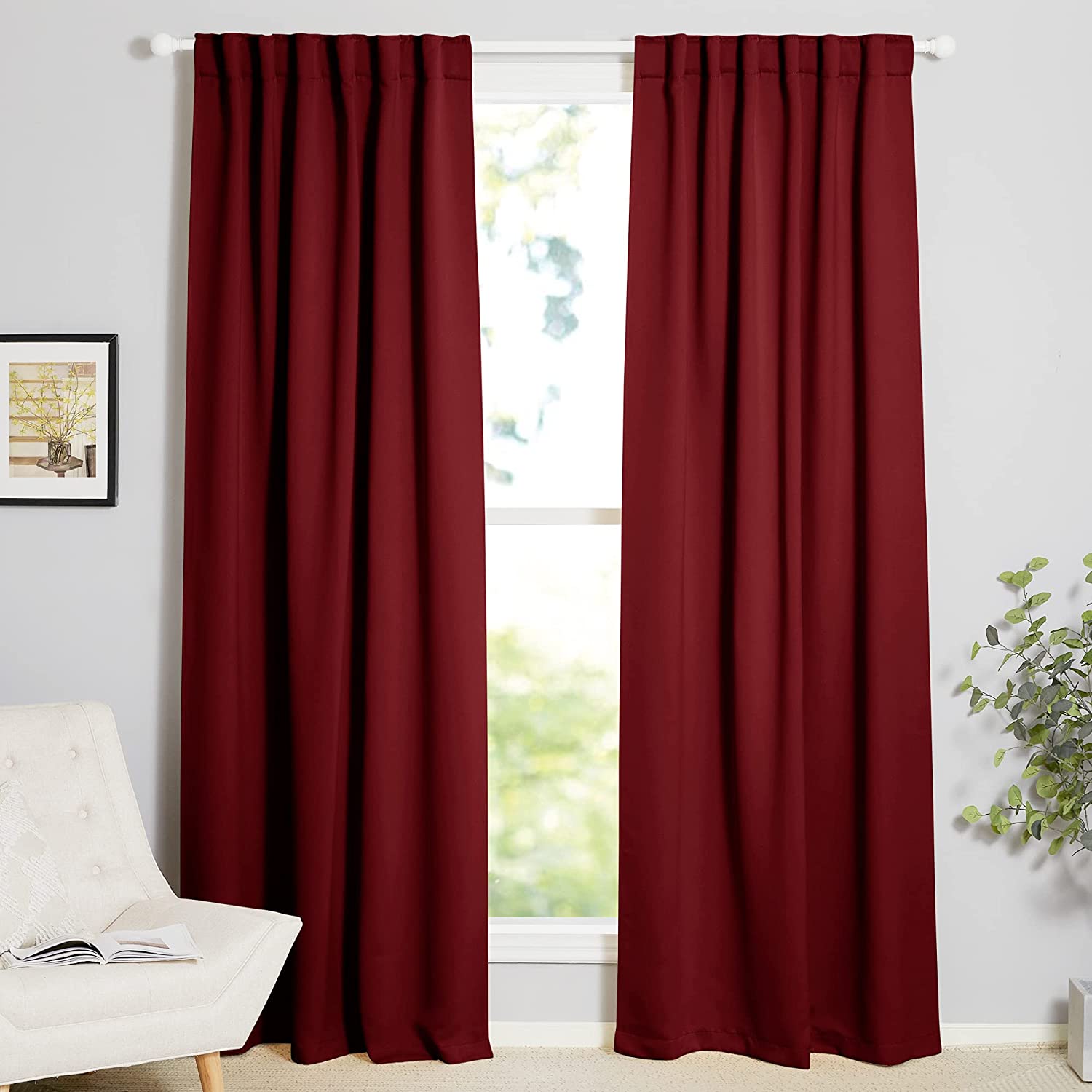 Two dark red thermal insulated blackout curtain panels with rod pocket and back tab, styled in a living room window.