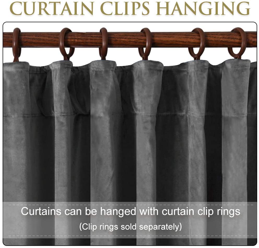 Dark grey velvet blackout curtain panel hung with brown clip rings on a wooden rod, demonstrating one hanging method.