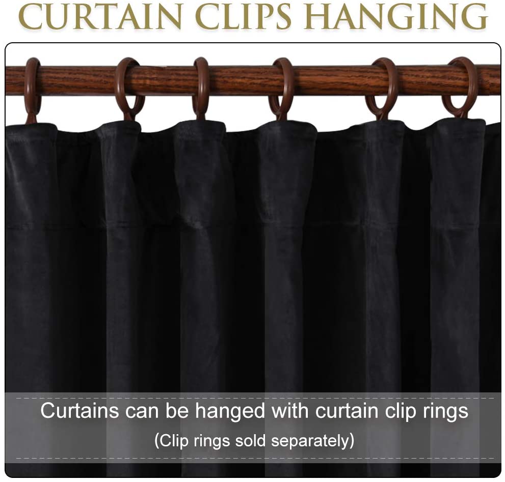 Black velvet blackout curtain hanging with brown clip rings on a wooden rod, for living room or bedroom.