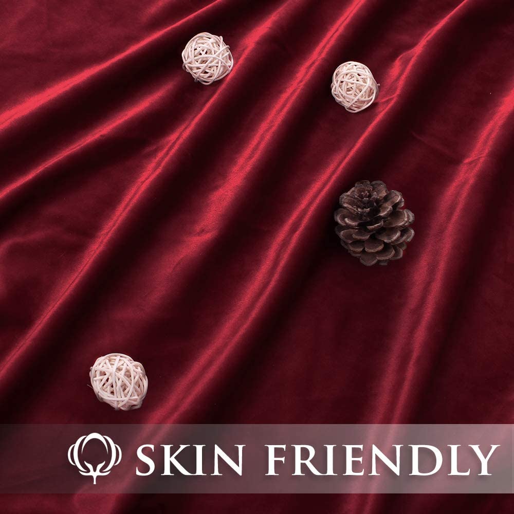 Luxurious deep red velvet blackout curtain fabric with elegant drapes, highlighting its soft, skin-friendly texture.