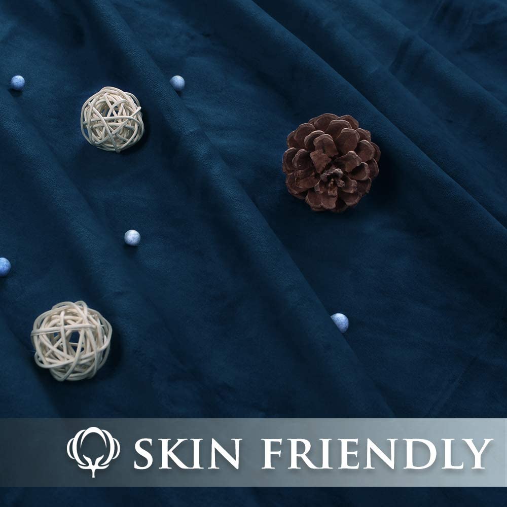 Close-up of rich dark blue velvet blackout curtain fabric with a pinecone. Text indicates "SKIN FRIENDLY" material, ideal for bedroom & living room use.