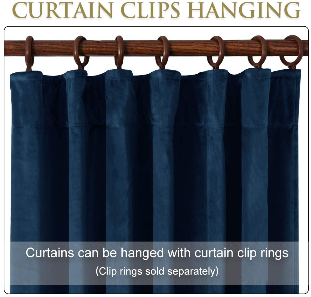 Dark blue velvet blackout curtain panel shown hanging from a wooden rod using brown clip rings, perfect for living room or bedroom.