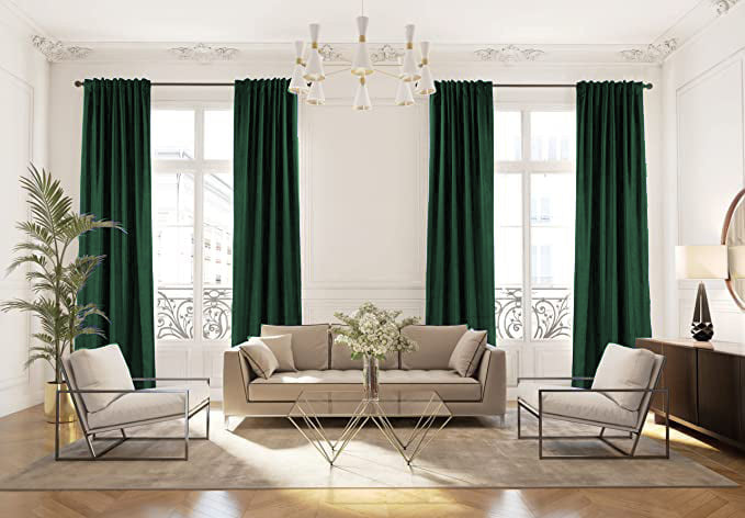 Two panels of dark green velvet rod pocket blackout curtains in a luxurious living room, ensuring privacy and room darkening.