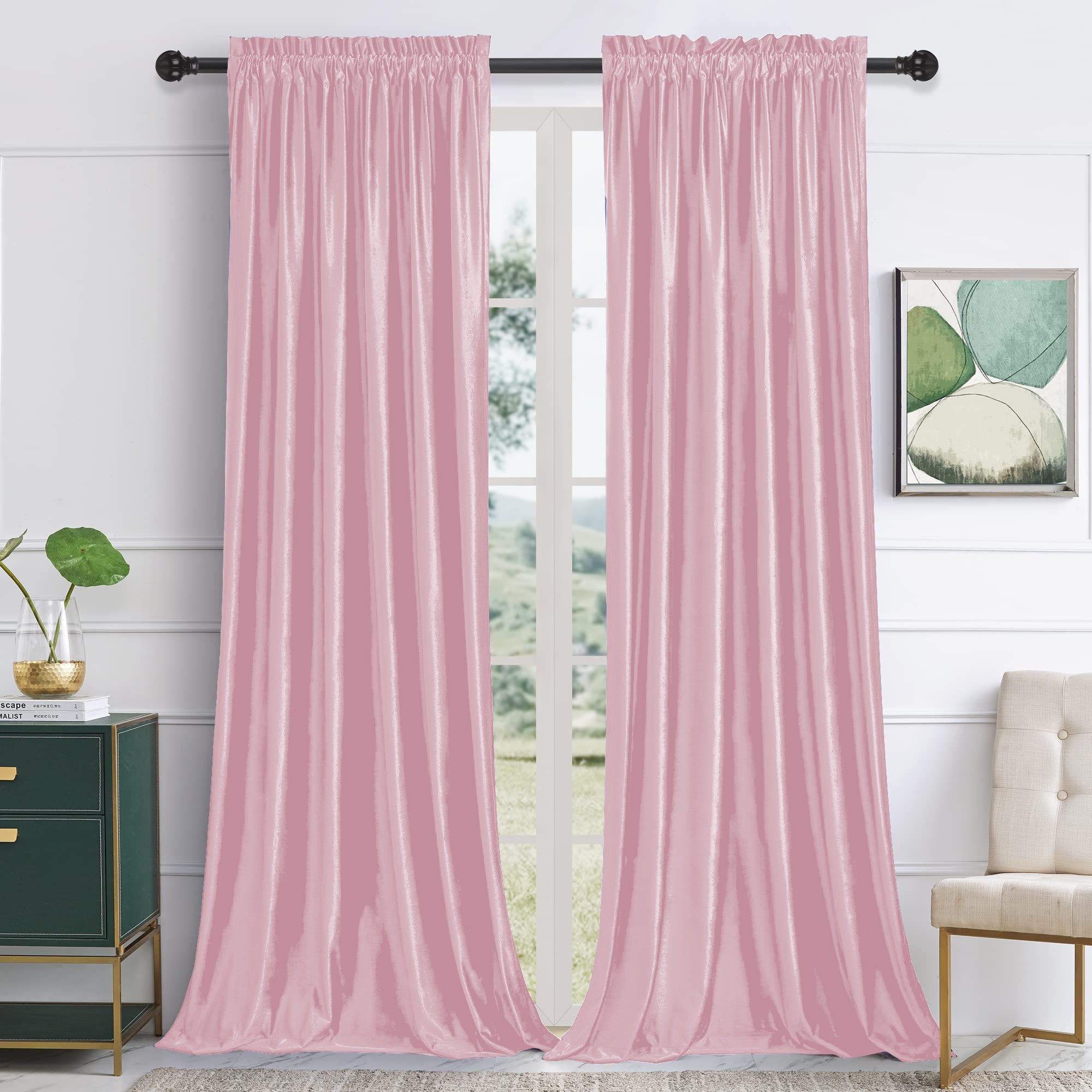 Two pink velvet rod pocket blackout curtains hang on a black rod, framing a window. Noise reducing panels for living room or bedroom.