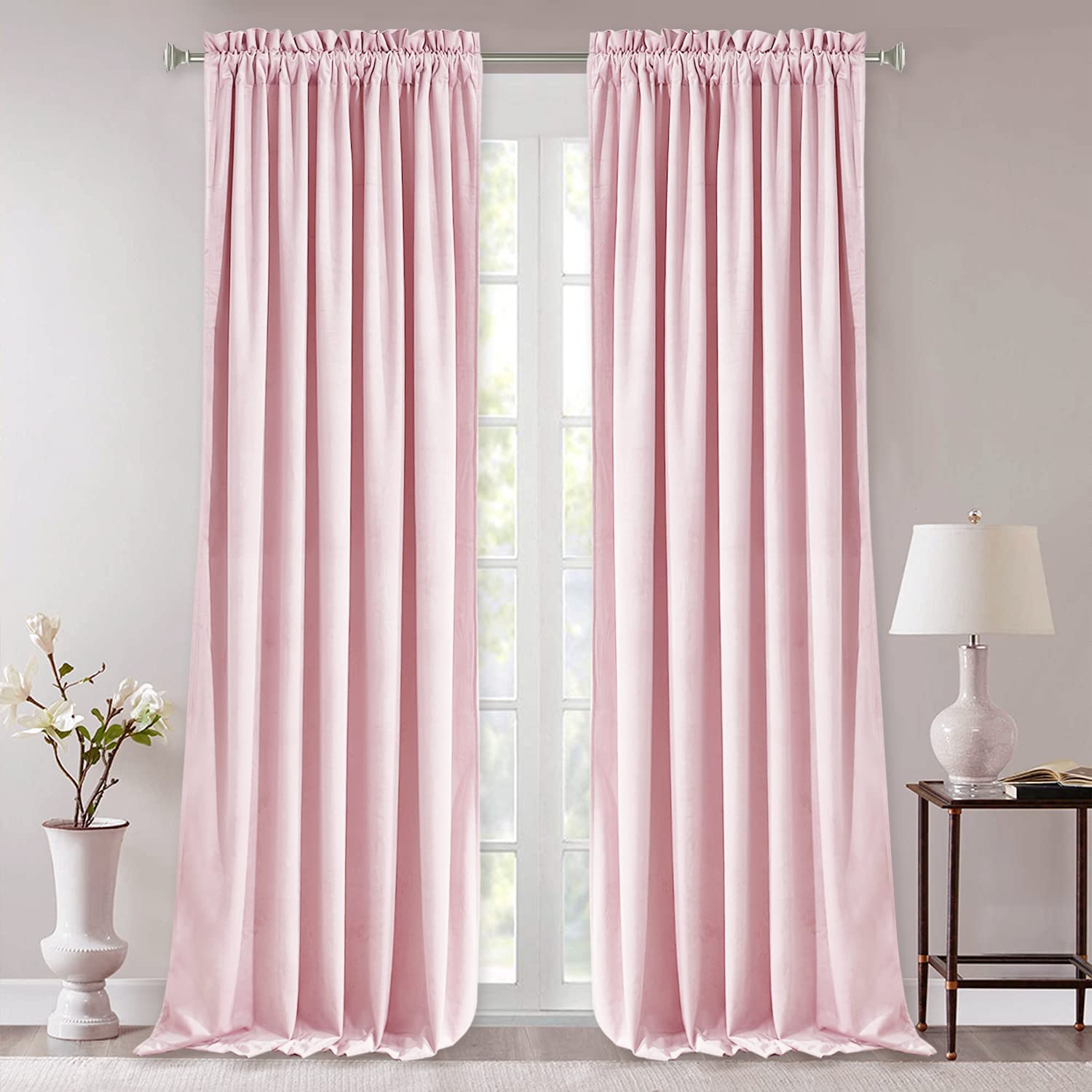 Blush pink rod pocket noise reducing blackout velvet curtains (2 panels) fully covering a living room or bedroom window.