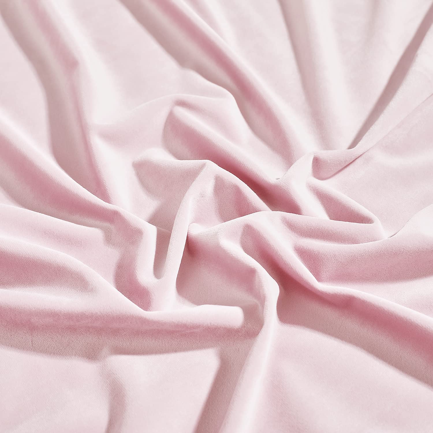 Luxurious soft pink velvet blackout curtain fabric draped to highlight its rich texture and opulent folds.