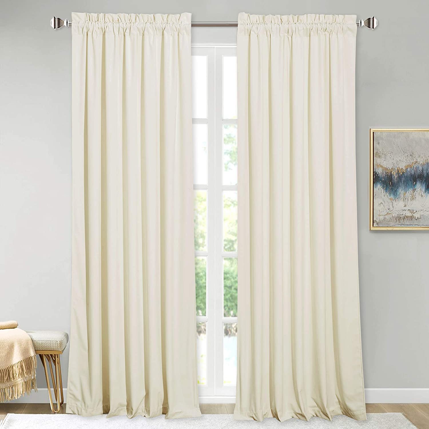Pair of cream velvet rod pocket curtains on a silver rod, offering blackout & noise reducing privacy for living room or bedroom.